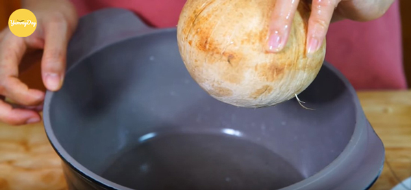 Cho nước dừa cùng tỏi ớt vào nồi