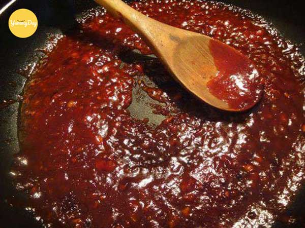 Cho cốt me vào xào chung với hành, tỏi, sả và gừng đã phi thơm